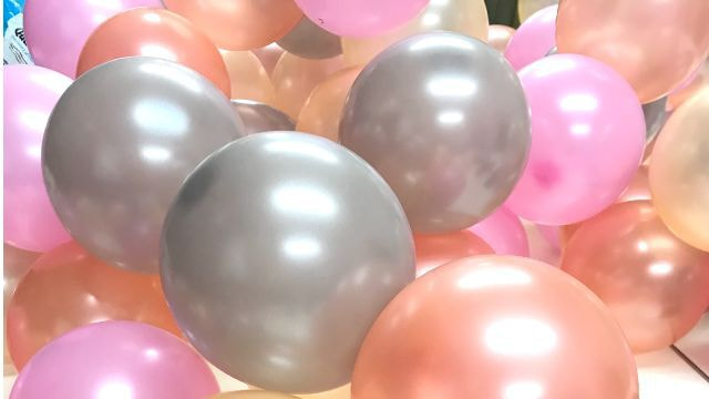 転がっているピンク、オレンジ、グレーの丸い風船