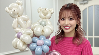 くまとお花のバルーンを持つピンクのセーターを着た20代の女性